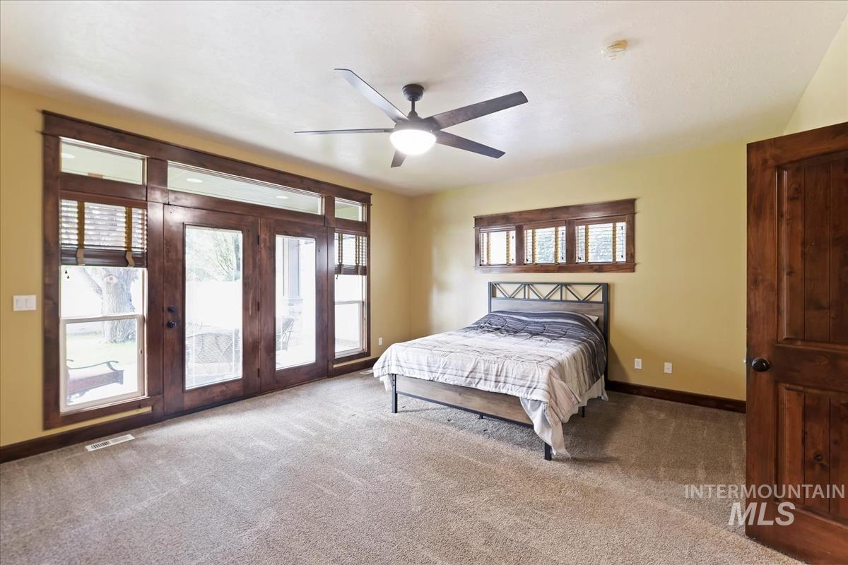 2543 West Divide Creek Street Meridian, ID 83646 - Photo 21 of 49 Bedroom with access to outside, multiple windows, carpet flooring, and a ceiling fan