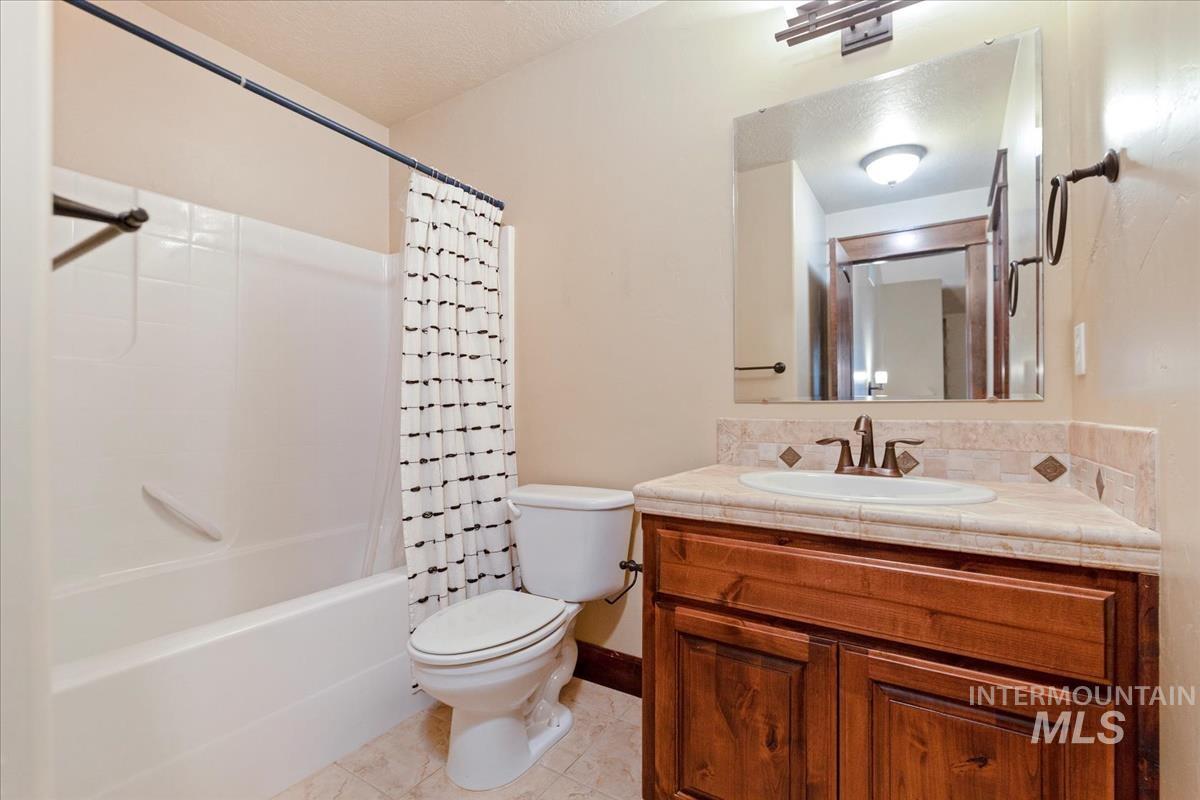 2543 West Divide Creek Street Meridian, ID 83646 - Photo 38 of 49 Full bath with shower / bath combination with curtain, vanity, and light tile patterned flooring