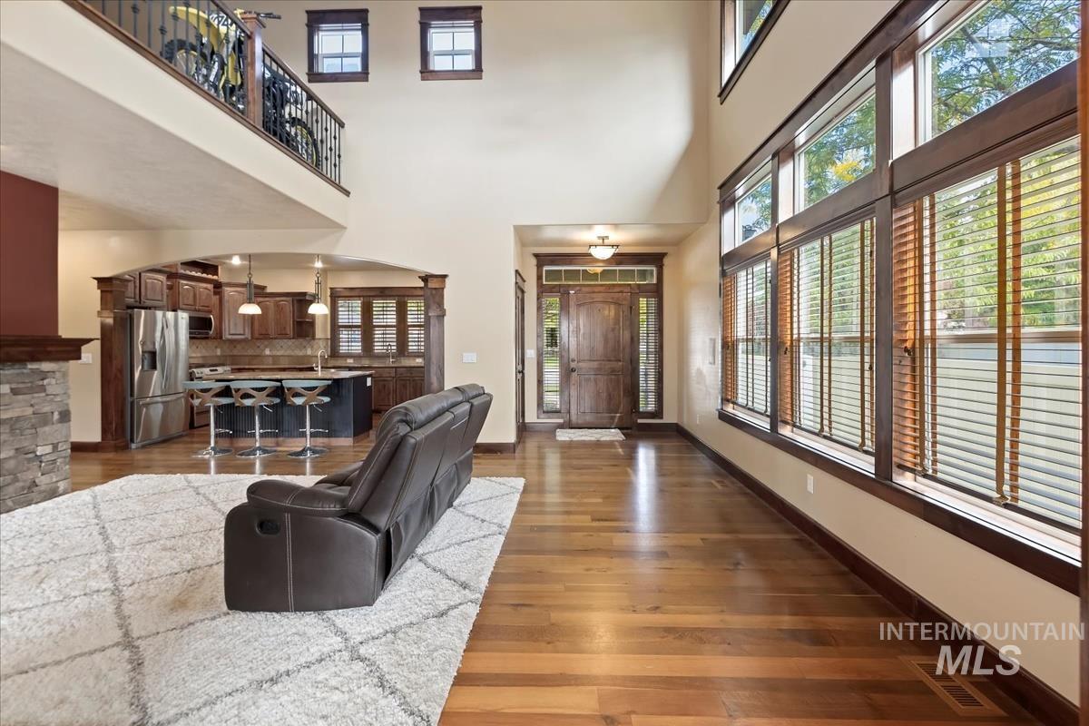 2543 West Divide Creek Street Meridian, ID 83646 - Photo 7 of 49 Living room with dark wood-style floors, arched walkways, and a high ceiling