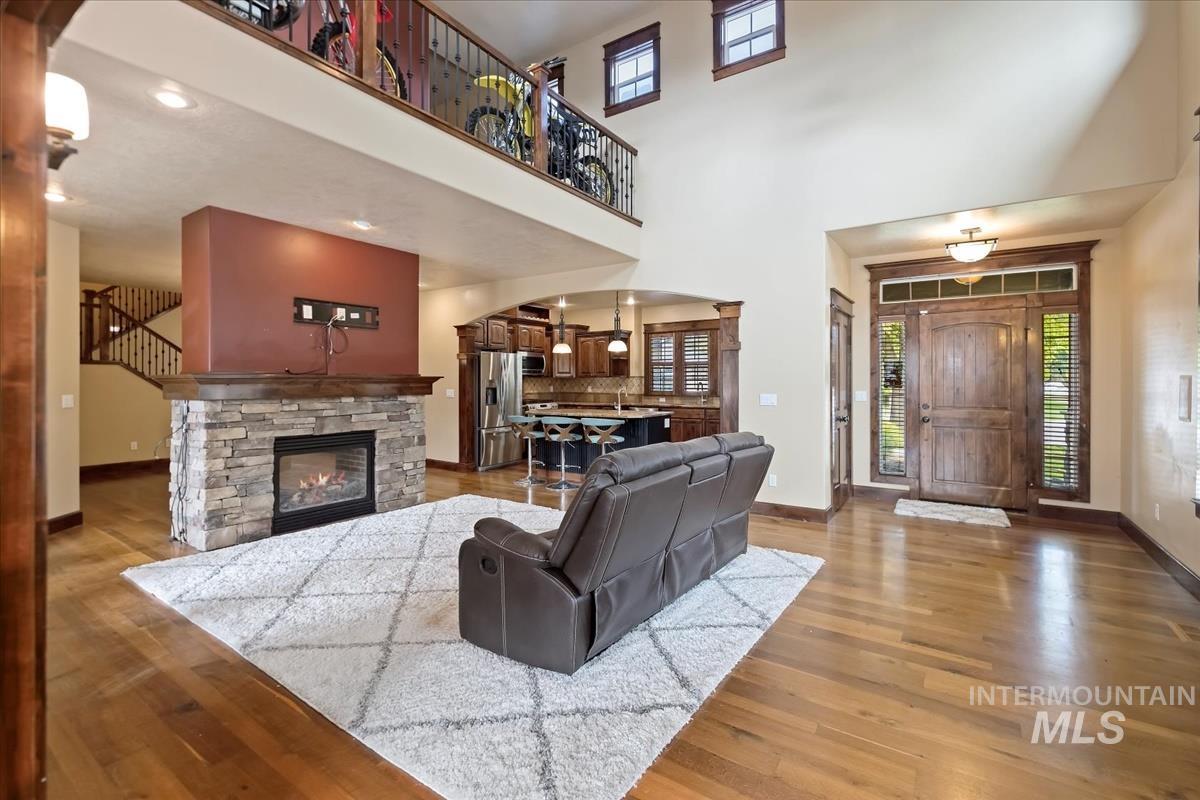 2543 West Divide Creek Street Meridian, ID 83646 - Photo 8 of 49 Living room with plenty of natural light, arched walkways, a fireplace, light wood-style floors, and a high ceiling