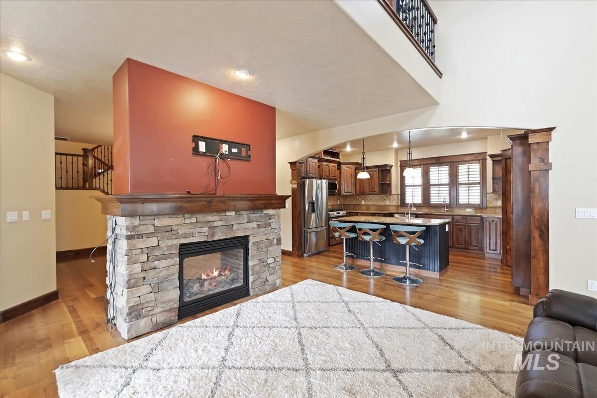 2543 West Divide Creek Street Meridian, ID 83646 - Photo 9 of 49 Living room featuring a fireplace, light wood-style floors, and arched walkways