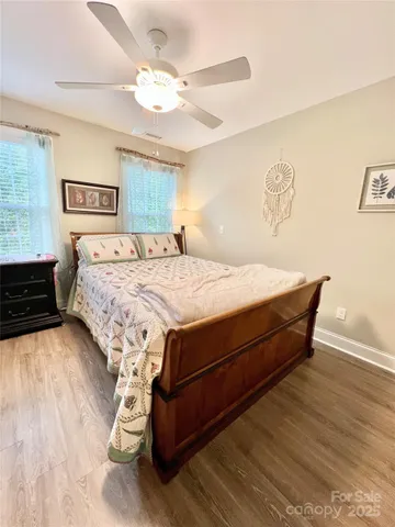 a bed sitting in a bedroom and wooden floor