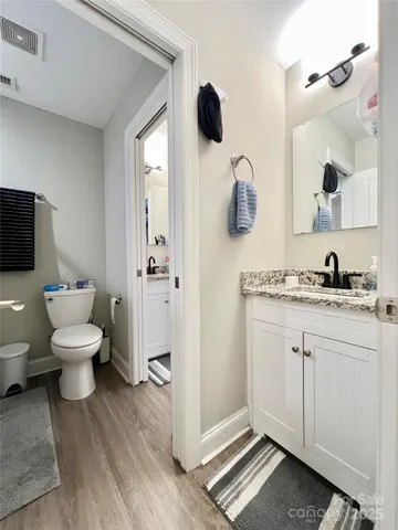 a bathroom with a granite countertop toilet sink and mirror