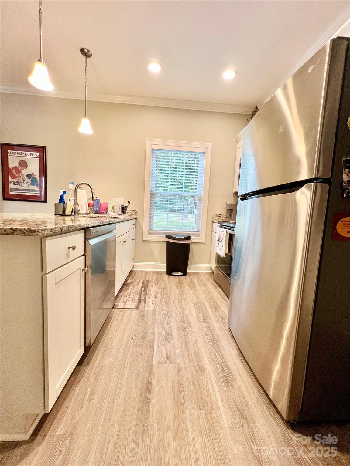 1781 17th Avenue Northeast Hickory, NC 28601 - Photo 9 of 26 a kitchen with stainless steel appliances granite countertop a refrigerator a sink dishwasher a stove and white countertops with wooden floor