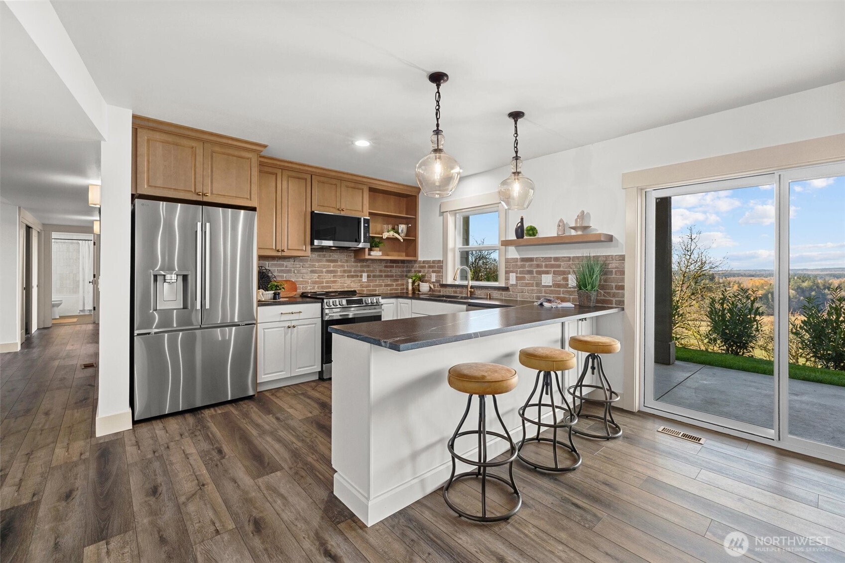 9813 Moran Road Arlington, WA 98223 - Photo 28 of 40 a kitchen with granite countertop a stove a sink dishwasher a refrigerator with a dining table and chairs