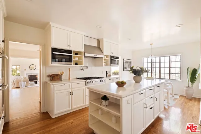 a kitchen with white cabinets and sink