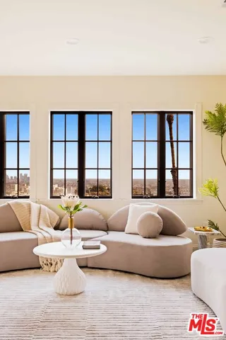 a living room with furniture a fireplace and a floor to ceiling window
