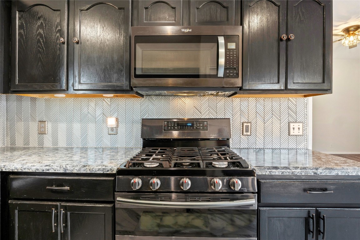 167 Hay Meadow Road Cedar Creek, TX 78612 - Photo 14 of 39 Kitchen featuring appliances with stainless steel finishes, backsplash, and light stone counters