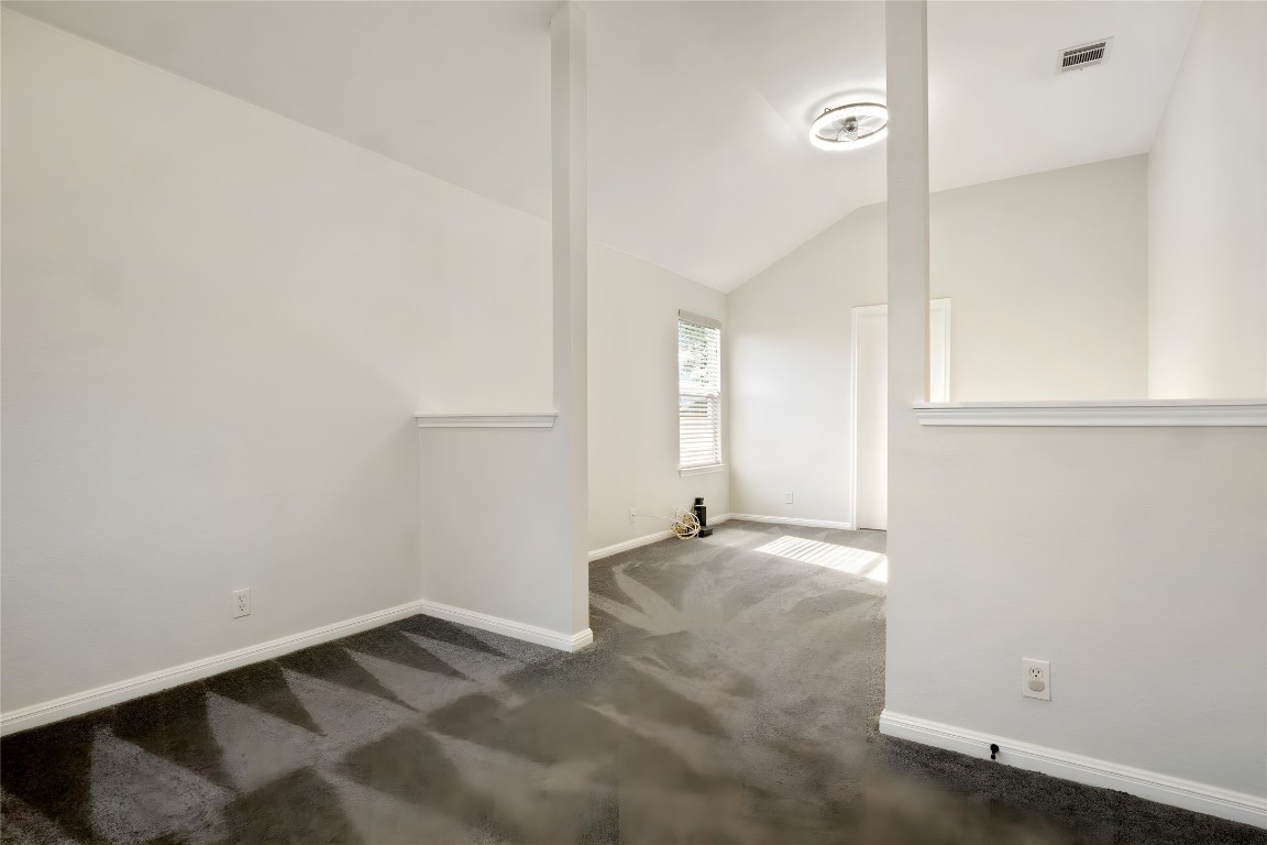 167 Hay Meadow Road Cedar Creek, TX 78612 - Photo 16 of 39 Primary bedroom featuring vaulted ceiling and dark carpet