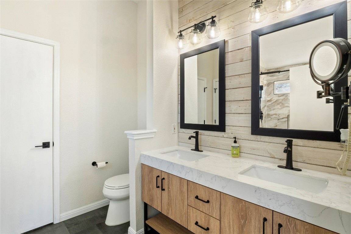167 Hay Meadow Road Cedar Creek, TX 78612 - Photo 20 of 39 Primary bathroom with double vanity and wood walls