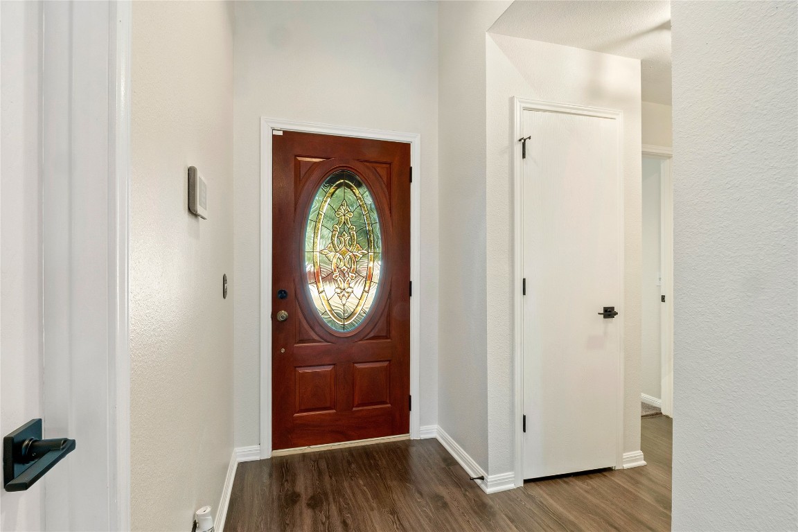 167 Hay Meadow Road Cedar Creek, TX 78612 - Photo 3 of 39 Foyer entrance featuring dark wood floors and a textured wall