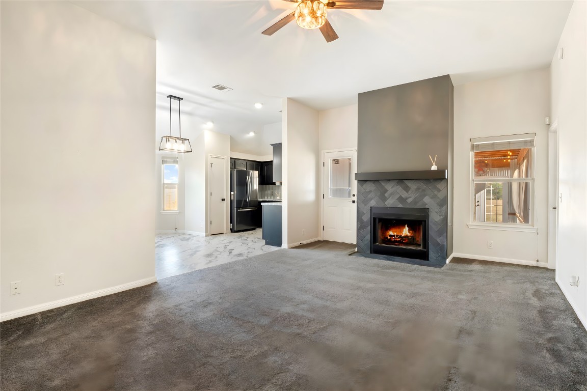 167 Hay Meadow Road Cedar Creek, TX 78612 - Photo 5 of 39 Living room featuring a tile fireplace, dark carpet and ceiling fan