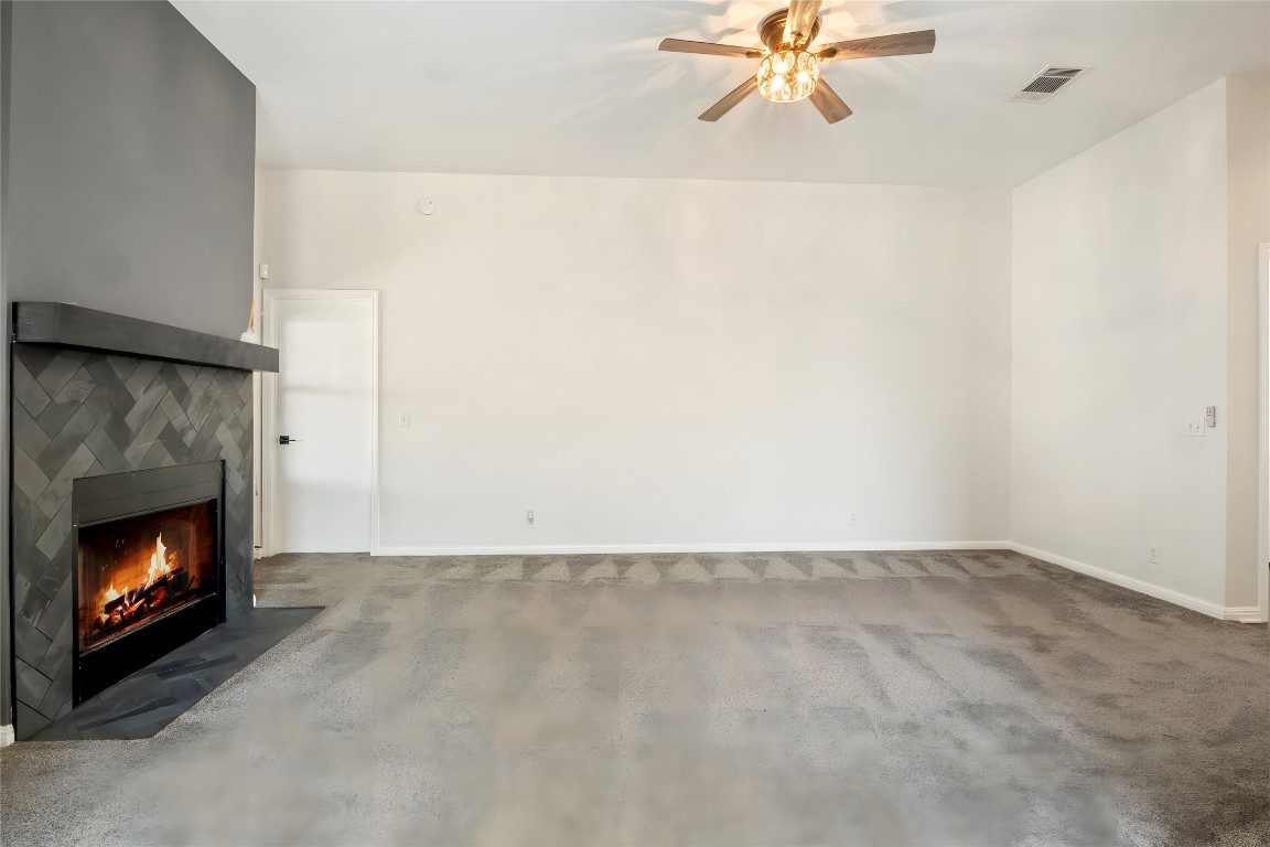 167 Hay Meadow Road Cedar Creek, TX 78612 - Photo 7 of 39 Living room featuring a tile fireplace, dark carpet and ceiling fan