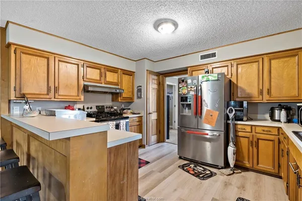 a kitchen with stainless steel appliances a refrigerator sink and cabinets