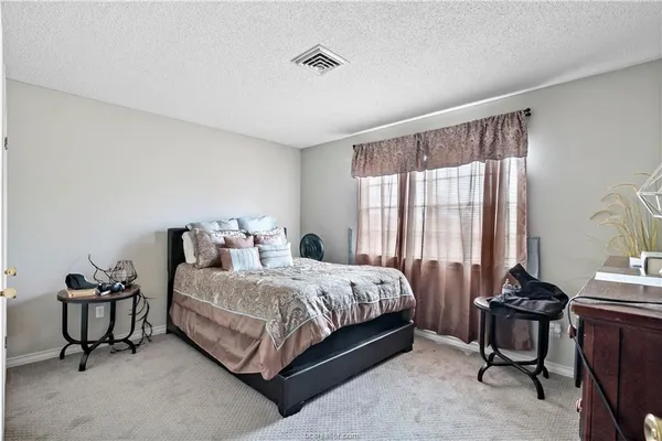 a bedroom with a bed chair and window