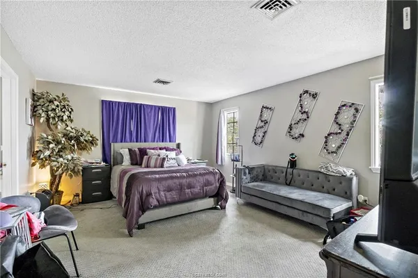 a spacious bedroom with a bed and a couch