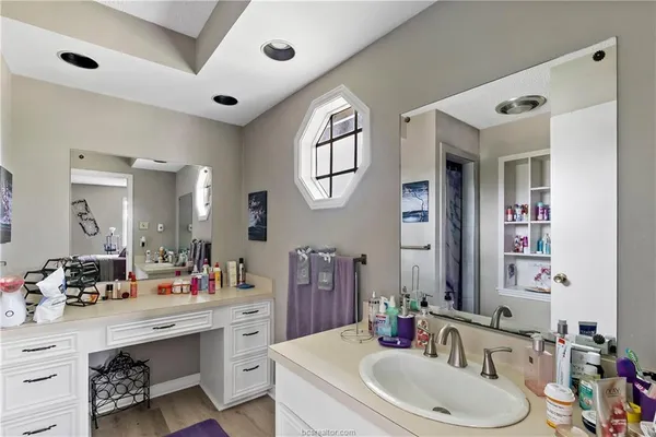a bathroom with a double vanity sink mirror and bathtub