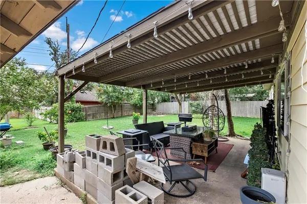 a view of a patio with table and chairs potted plants with large tree