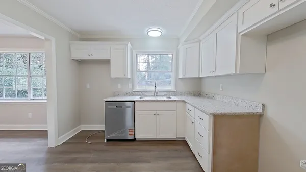 a kitchen with granite countertop white cabinets and white appliances
