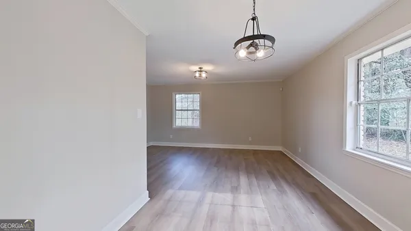 a view of a room with wooden floor fan and window