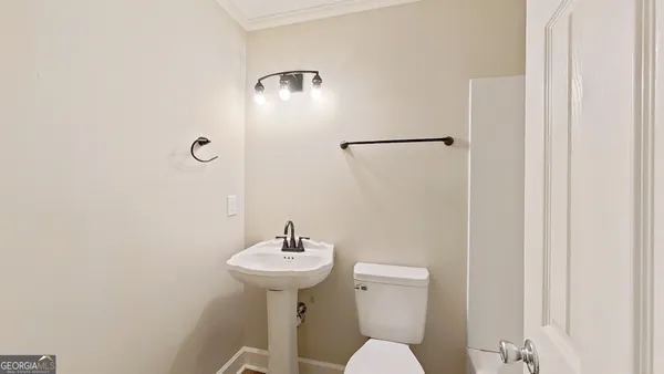 a bathroom with a sink toilet and a mirror