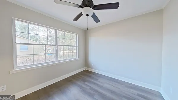 an empty room with a window and a ceiling fan