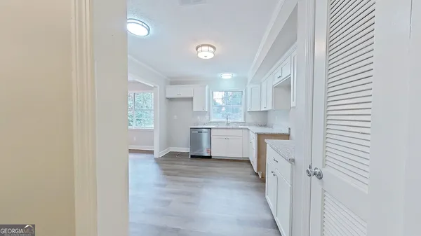 a view of a kitchen with a sink and dishwasher a refrigerator with wooden floor
