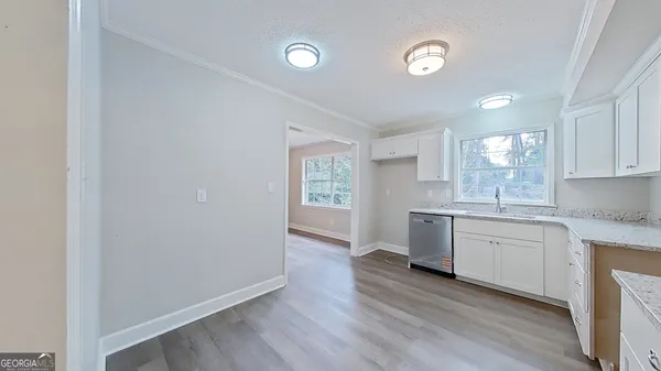 a kitchen with granite countertop white cabinets and white appliances