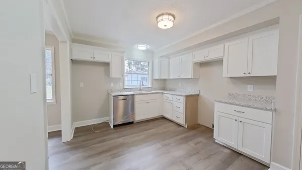 a kitchen with granite countertop white cabinets and white appliances