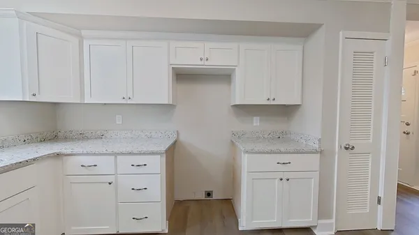 a kitchen with granite countertop white cabinets and a stove
