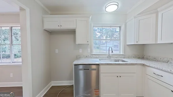 a kitchen with a sink window and cabinets