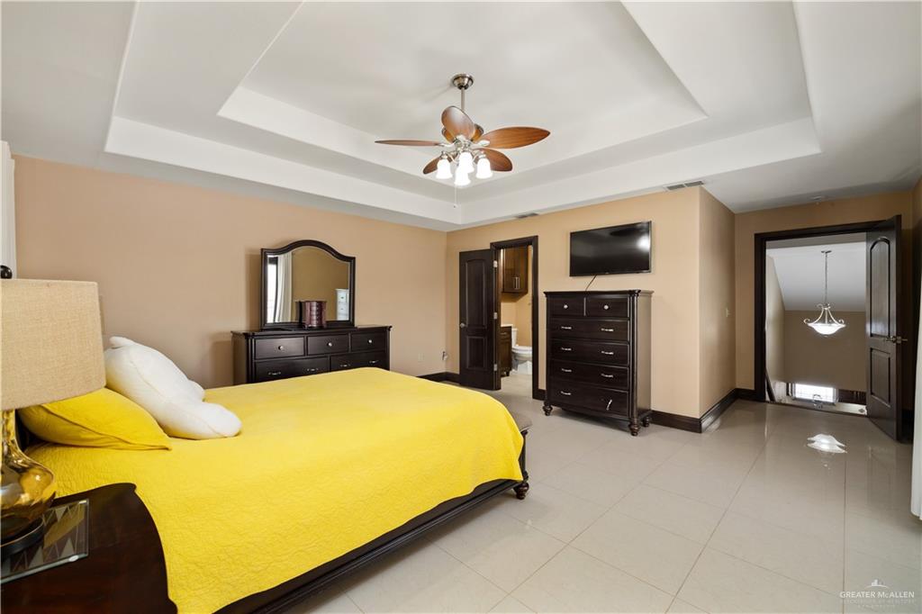 1257 Riverside Street Rio Grande City, TX 78582 - Photo 13 of 28 a bedroom with a bed and a chandelier