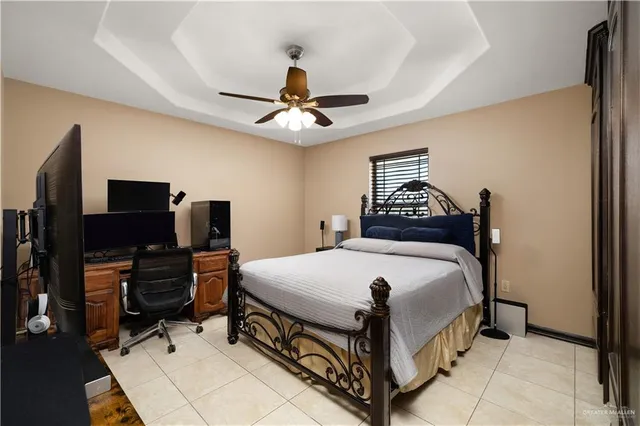 a bedroom with a bed and a flat tv screen on the dresser
