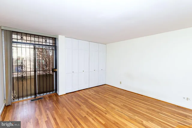 a view of an empty room with wooden floor