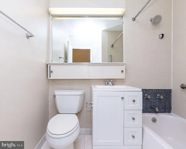 a bathroom with a sink toilet vanity and bathtub