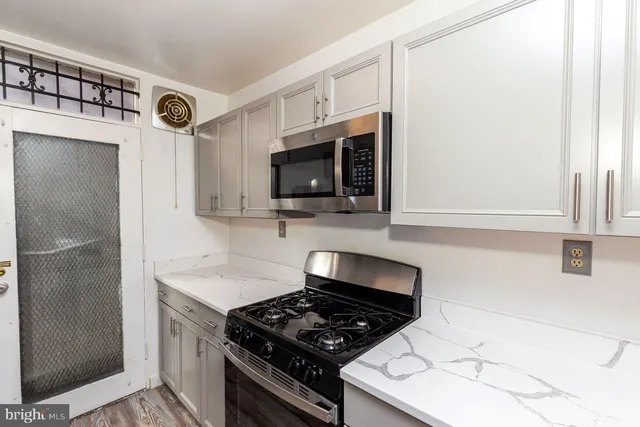 a kitchen with stainless steel appliances granite countertop a stove and a microwave