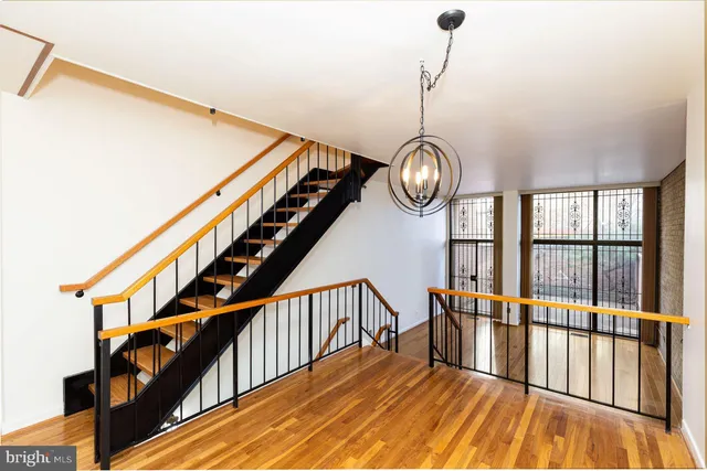 a view of hallway with wooden floor and stairs