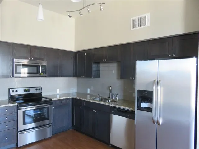 a kitchen with a sink a refrigerator and cabinets