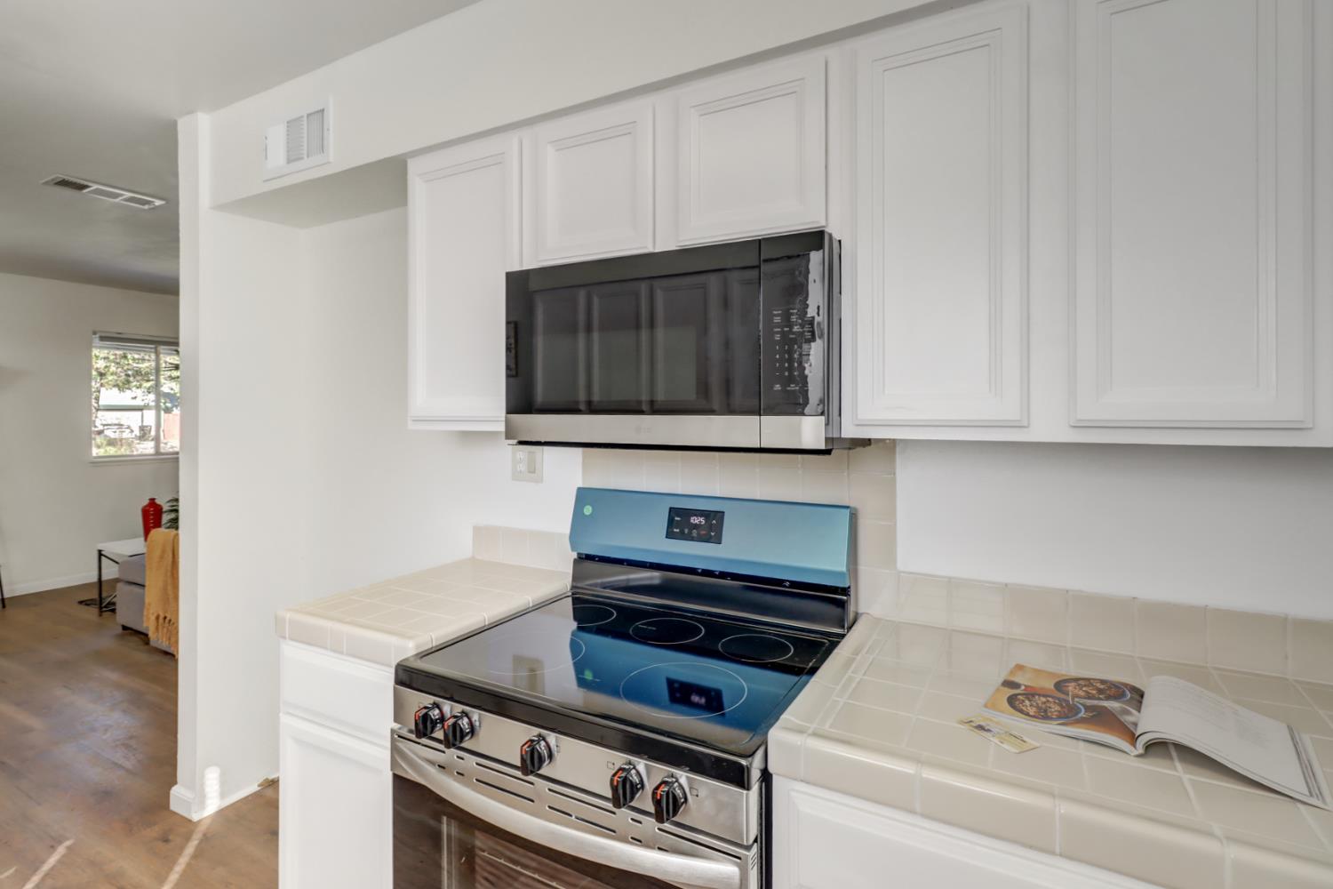 10556 Olson Drive Rancho Cordova, CA 95670 - Photo 17 of 46 a kitchen with granite countertop a stove and a microwave