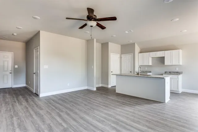 a view of kitchen with granite countertop cabinets and wooden floor