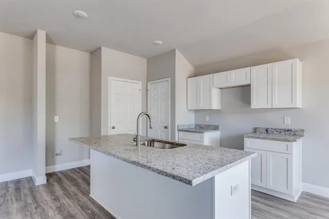 a kitchen with stainless steel appliances granite countertop a sink stove and cabinets