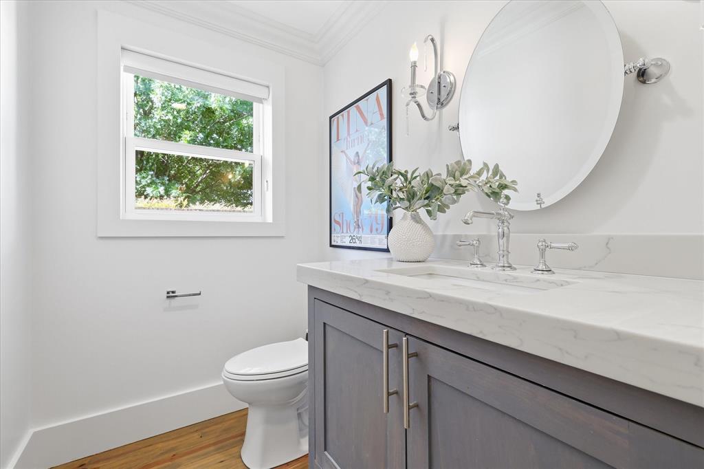 4310 Forest Bend Road Dallas, TX 75244 - Photo 32 of 40 Powder room featuring a single-sink vanity with a quartz countertop, chrome fixtures, and a wall-mounted oval mirror