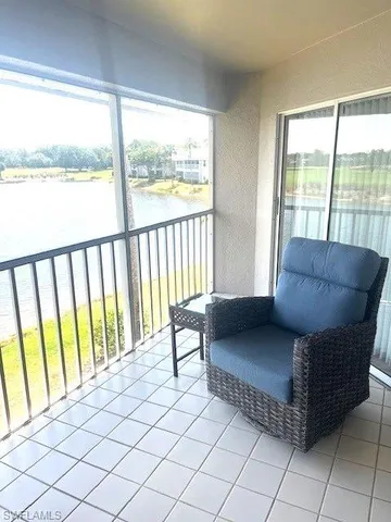 a living room with furniture and a floor to ceiling window