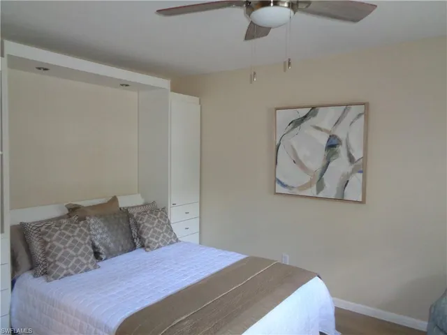 a bedroom with a bed and painting on the wall