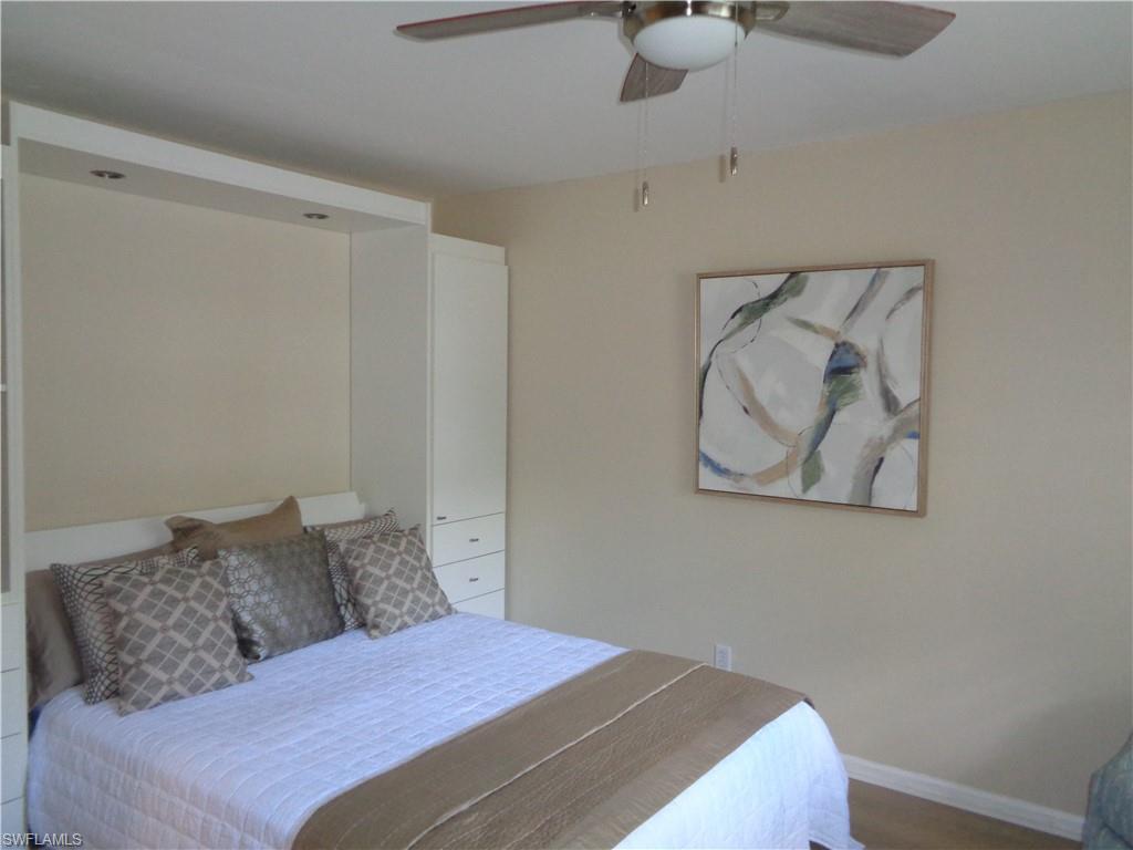 6250 Bellerive Avenue, Unit 5 Naples, FL 34119 - Photo 25 of 37 a bedroom with a bed and painting on the wall