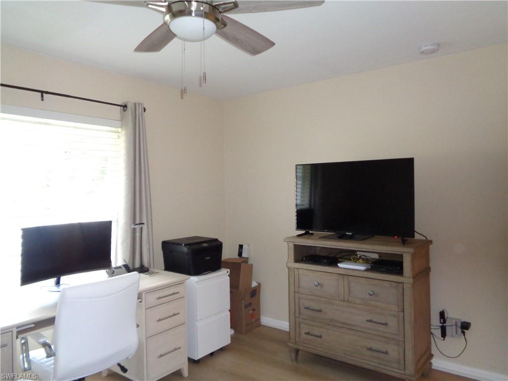 6250 Bellerive Avenue, Unit 5 Naples, FL 34119 - Photo 27 of 37 a bedroom with a bed and a flat screen tv