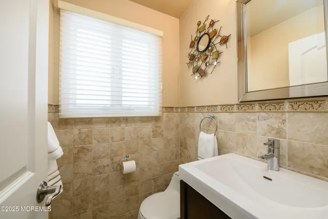 a bathroom with a sink a toilet and a mirror