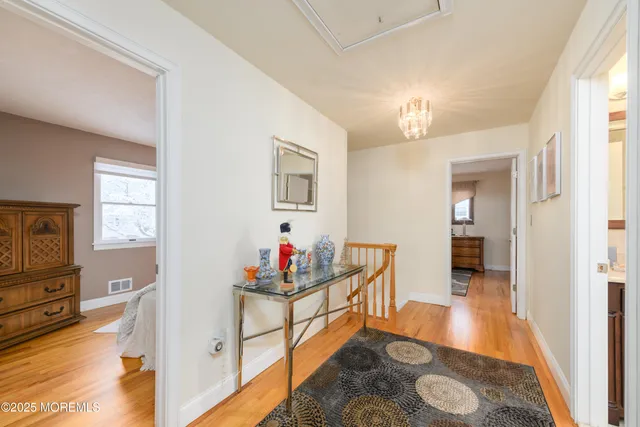 a hall way with furniture and mirror with wooden floor