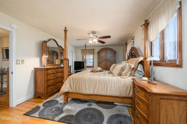 a bedroom with a bed and dresser with mirror
