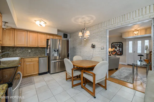 a kitchen with a dining table chairs and refrigerator